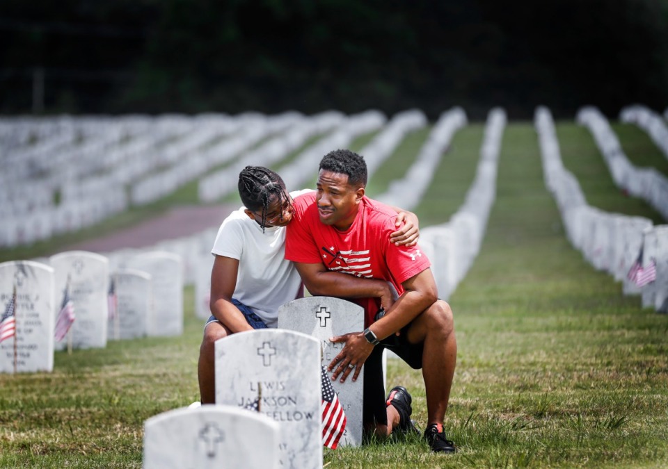 <strong>C.J. Warren, 15, (left) comforts his father Corey Warren, while they visit the grave of Rodney Warren on Memorial Day, Monday, May 30, 2022 at the West Tennessee State Veterans Cemetery.</strong> (Mark Weber/The Daily Memphian)