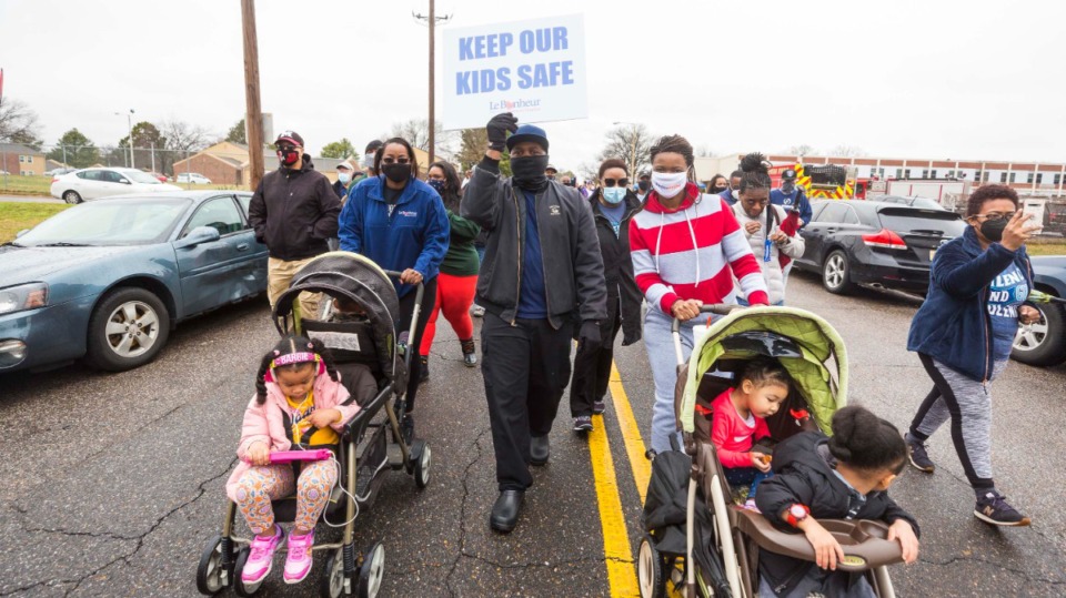 <strong>Louis Cooper holds sign walking with (left to right,) Anissa Revels and Tracy Jones during Unity Walk against Violence at Hilcrest High School in Whitehaven on February 27, 2021.</strong>(Ziggy Mack/Special to The Daily Memphian)
