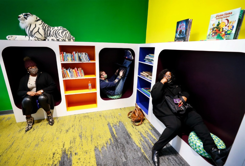 <strong>Berlinda Williams-Strong (from left), Christy Kirchner and Kim Fluker test out the children-size reading cubbyholes during a tour of the new Raleigh Library on Dec. 4, 2020, at the Raleigh Springs Civic Center. The library will host an Explore Memphest festival in July.</strong>&nbsp;(Mark Weber/Daily Memphian file)
