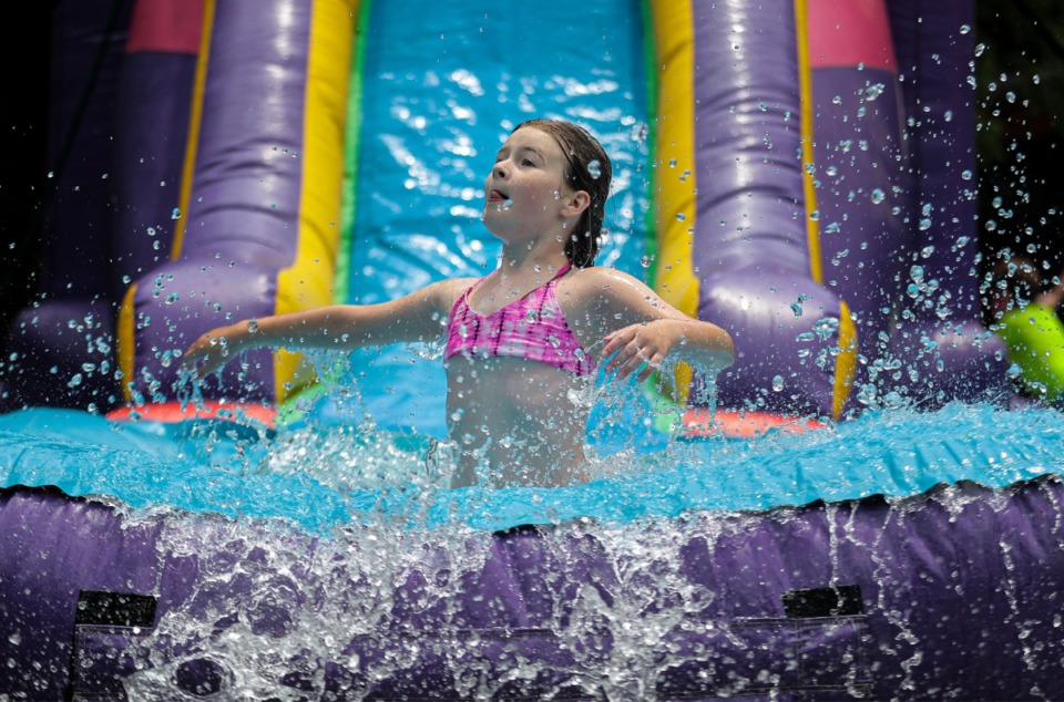 <strong>A Camp Able camper slides into a bouncy pool at St. Columba in Bartlett June 7, 2022.</strong> (Patrick Lantrip/The Daily Memphian)