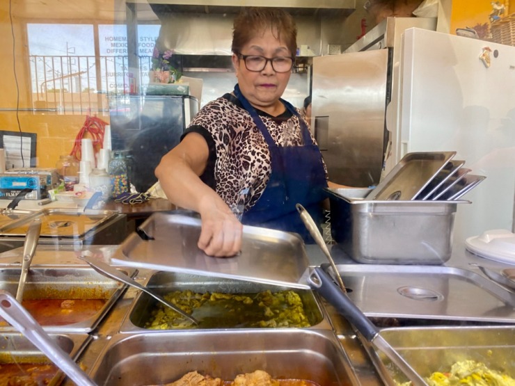 Maria Ahedo serves up lunch behind the counter at La Llamarada on Summer Avenue. (Chris Herrington/The Daily Memphian)