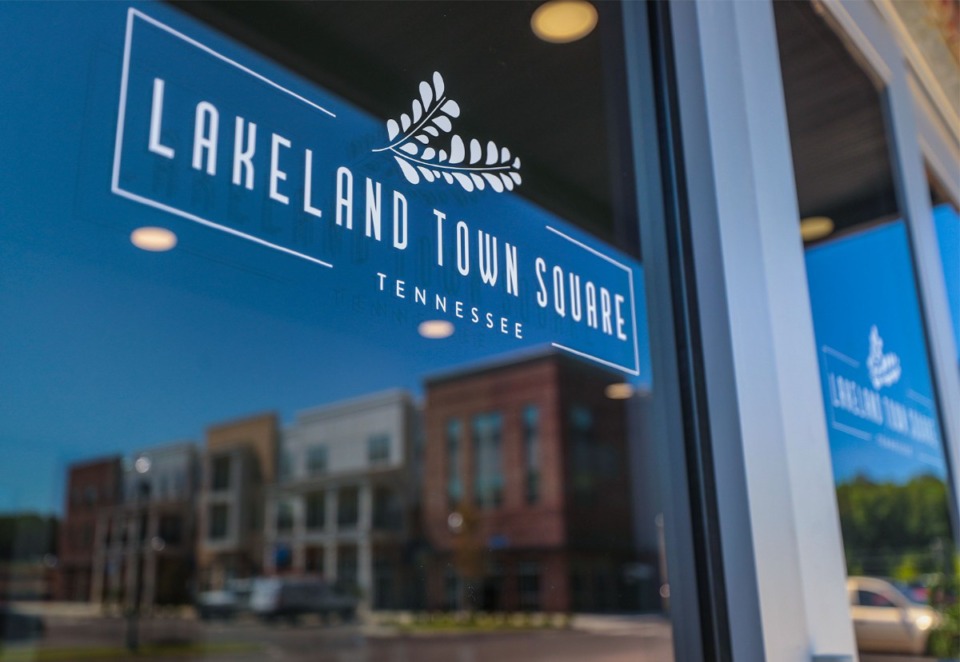 <strong>One of the completed buildings in the Lakeland Town Square development reflects in the window of the leasing office on June 23, 2022.</strong> (Patrick Lantrip/Daily Memphian)