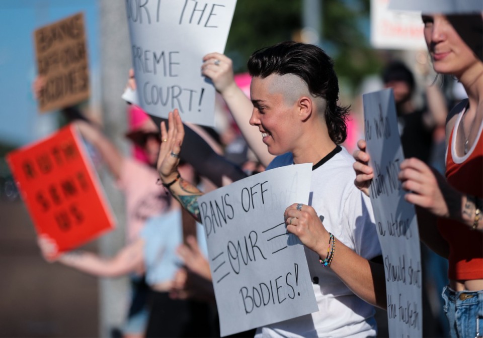 <strong>Leah Tucker waves at honking cars during a protest at the intersection of Poplar Avenue and McLean Boulevard on June 24, 2022.</strong> (Patrick Lantrip/Daily Memphian)