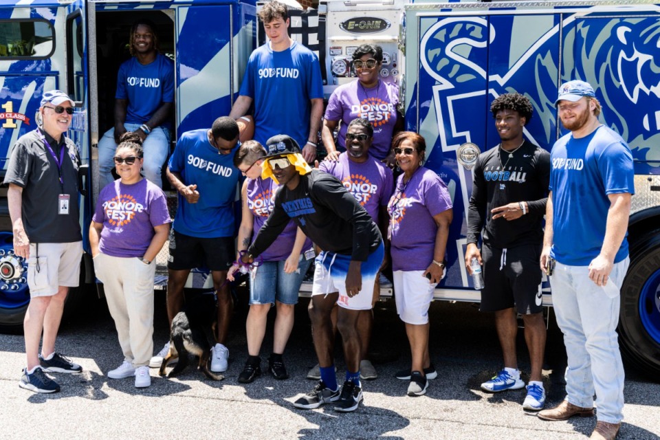 <strong>University of Memphis football players help attract blood donors in front of the Memphis Fire Department&rsquo;s &ldquo;Tiger Pumper&rdquo; during Vitalant Donor Fest Saturday in Overton Square.</strong> (Brad Vest/Special to The Daily Memphian)