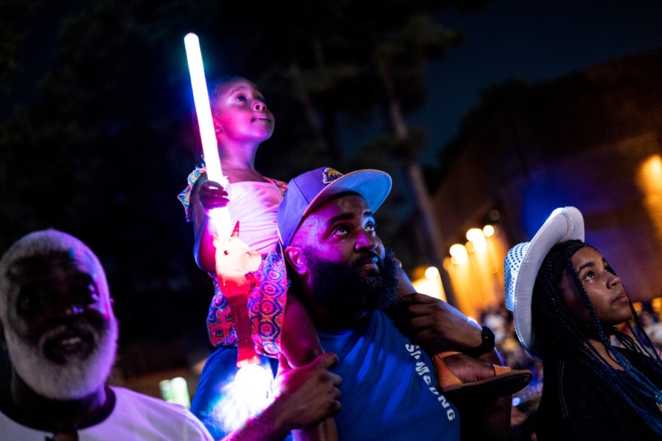 <strong>Gregory Seals II holds his daughter, Kennedy Seals, 4, so she can get a better view of the fireworks Saturday at Collierville&rsquo;s annual Independence Day celebration at H. W. Cox Park.</strong> (Brad Vest/Special to The Daily Memphian)