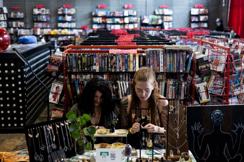 <strong>Alice Gleadhill (left) and Abbay Gourley work on jewelry at their Prima Botanica table during Art Bazaar at Black Lodge Video. Art Bazaar is a popup artist vendor event that includes musical performances and a fashion show.</strong> (Brad Vest/Special to The Daily Memphian)