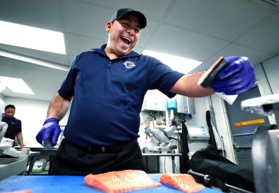 <strong>Froylan "Fro" Santiago, chef manager at Soul Fish on Cooper, cuts and weighs fresh salmon fillets that will soon be used on salads and dinner plates. Santiago says the restaurant on Cooper Street goes through about 200 pounds of fish per week.</strong> (Houston Cofield/Daily Memphian)