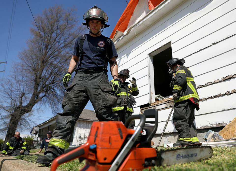 <strong>Privates Tom Moore, Mike Dotson and Jeff Sharp of the Memphis Fire Department&rsquo;s Station 6 Truck 2 B-shift practice potentially life-saving maneuvers on a blighted, vacant house at the corner of Willett Street and Chelsea Avenue that the city is scheduled to demolish as part of its blight remediation efforts.</strong> (Patrick Lantrip/Daily Memphian)