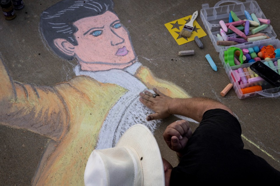 <strong>Greg Damron works on sidewalk art of Elvis along Elvis Presley Boulevard during the Elvis Week 2021 Candlelight Vigil. Elvis Week 2022 kicks off Aug. 9 and runs through Aug. 17.</strong> (Brad Vest/Special to The Daily Memphian)