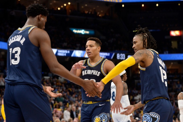 Memphis Grizzlies forward Jaren Jackson Jr. (13), and guards Desmond Bane (22) and Ja Morant (12) give each other fives in the second half during Game 5 of a first-round NBA basketball playoff series against the Minnesota Timberwolves Tuesday, April 26, 2022, in Memphis, Tennessee. (AP Photo/Brandon Dill)