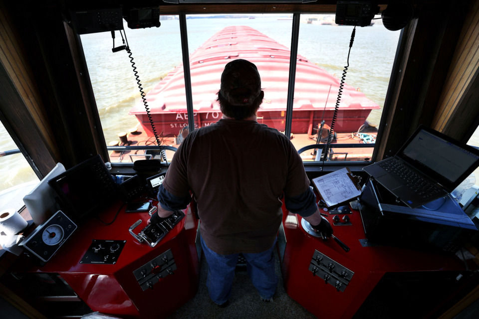 <strong>Captain Robert Smith, a boat captain for Wepfer Marine, traverses through McKellar Lake with an empty barge that will soon be loaded with goods to take down the Mississippi River. Smith has been with Wepfer for 20 years and says the river presents a new challenge every day.</strong> (Houston Cofield/Daily Memphian)