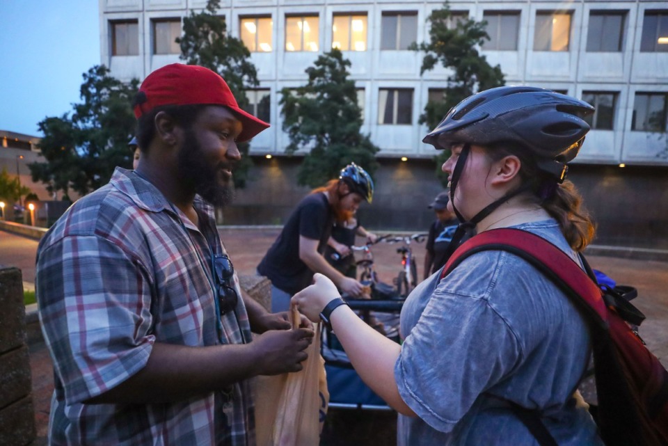 <strong>Allison Udell hands out food to hungry Memphians along her route while delivering burritos for the Urban Bicycle Food Ministry. The ministry&nbsp;owns 40 donated bikes.</strong> (Patrick Lantrip/The Daily Memphian)