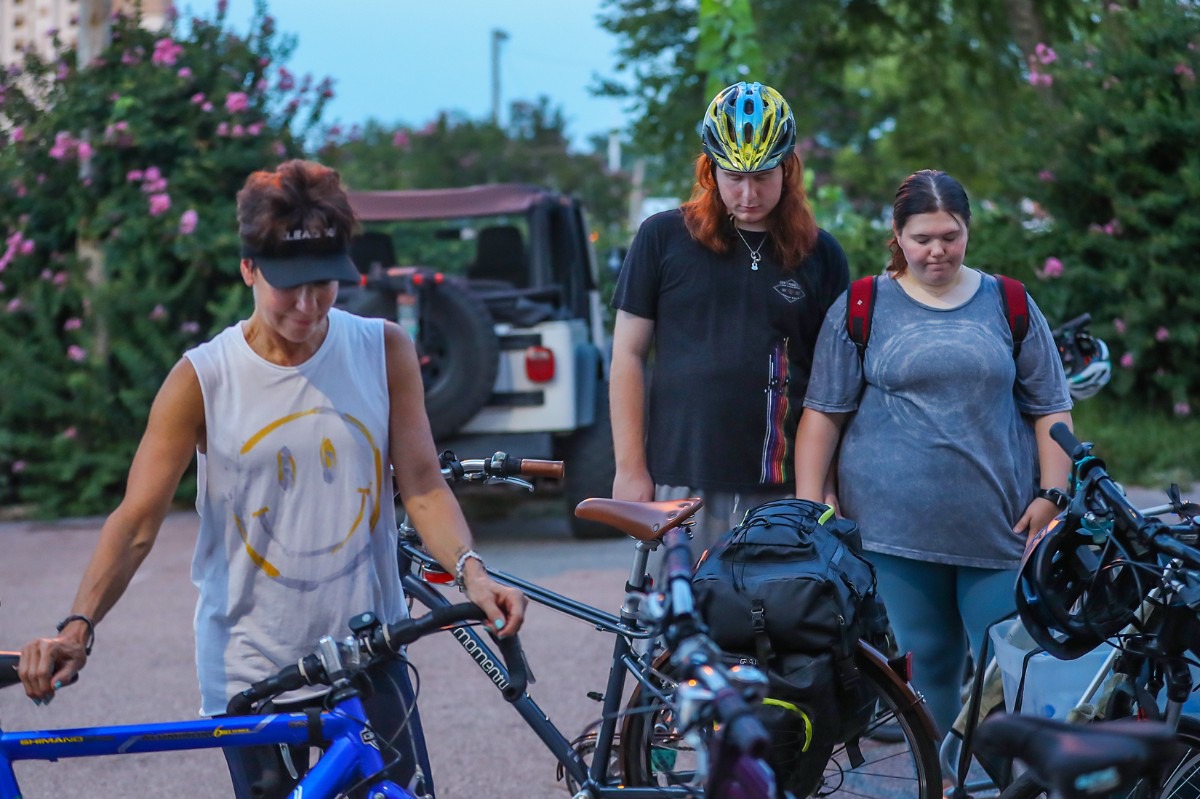 <strong>Dade Rohr and Allison Udell (right) pray before their bike ride to pass out food and supplies to homeless Memphians Aug. 3, 2022.</strong> (Patrick Lantrip/Daily Memphian)