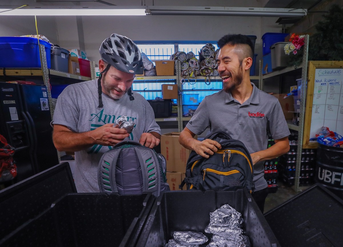 <strong>Members of the Urban Bicycle Food Ministry Jason Morgan (left) and Tawatos Phadungsoondararak (right) fill their backpacks with burritos. The ministry has delivered homemade burritos every Wednesday for 10 years.&nbsp;</strong>(Patrick Lantrip/The Daily Memphian)