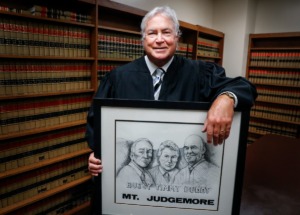 <strong>Drug Court Judge Tim Dwyer hold a print of himself and his uncles Buddy Dwyer and Judge Robert Dwyer. After 38 years, Judge Dwyer will be retiring from the bench at the end of August.</strong> (Mark Weber/The Daily Memphian)