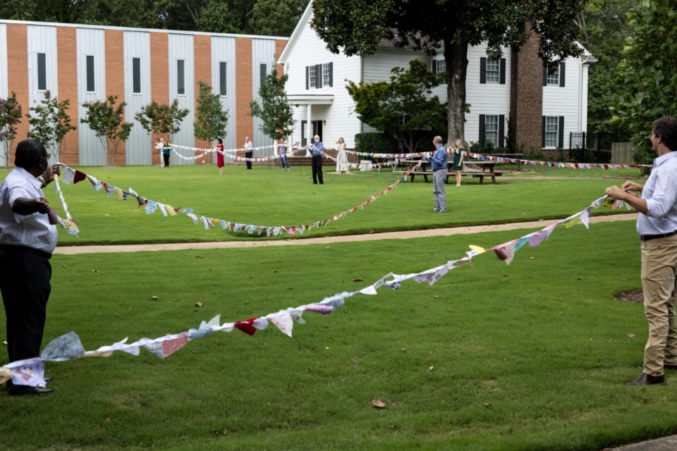 <strong>Members of Holy Trinity Episcopal Church at 3745 Kimball Ave. unfurl a chain of fabric hearts they&rsquo;ll send to a congregation in Vestavia Hills, Ala. where 3 parishioners were killed in a mass shooting in June.</strong> (Brad Vest/Special to The Daily Memphian)