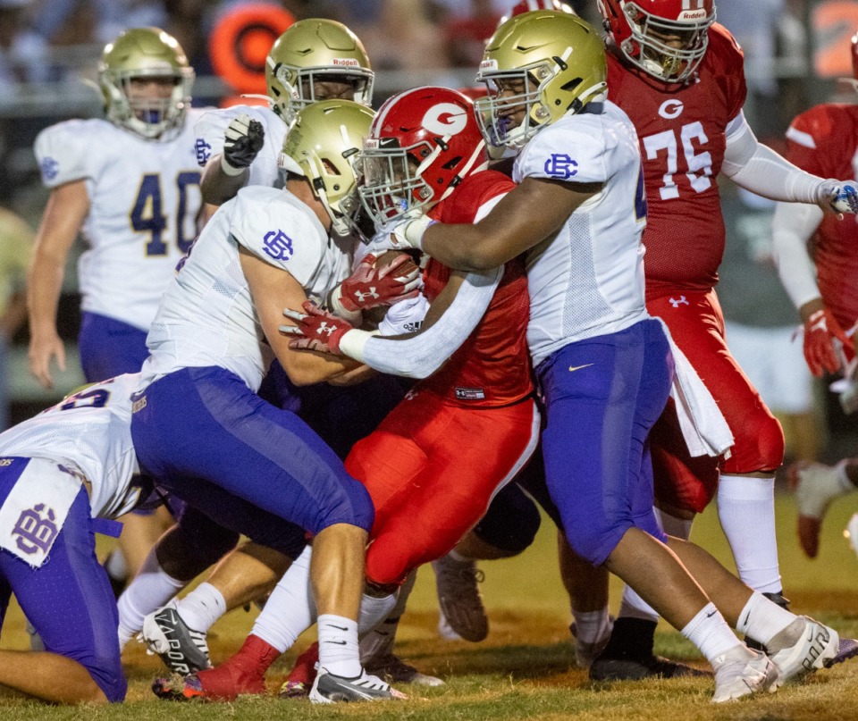 <strong>Germantown's BJ Blake is stopped by CBHS's Garrett Lee and Zane Beard after making a short gain in a hard-fought ground game at Germantown High School, Saturday, Aug. 20, 2022.</strong> (Greg Campbell/Special to The Daily Memphian)
