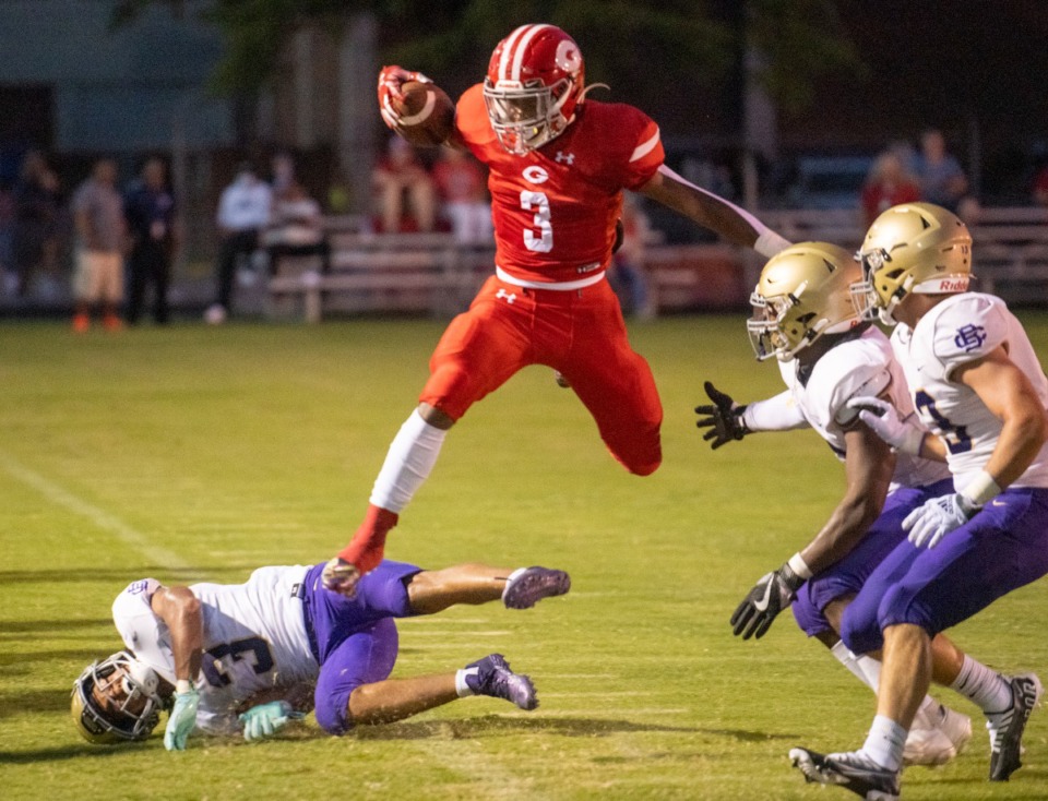 <strong>Germantown back Malik Mason makes extra yards by leaping for a first down over CBHS's Joshua Thurman in their contest at Germantown High School, Saturday, Aug. 20, 2022.</strong> (Greg Campbell/Special to The Daily Memphian)