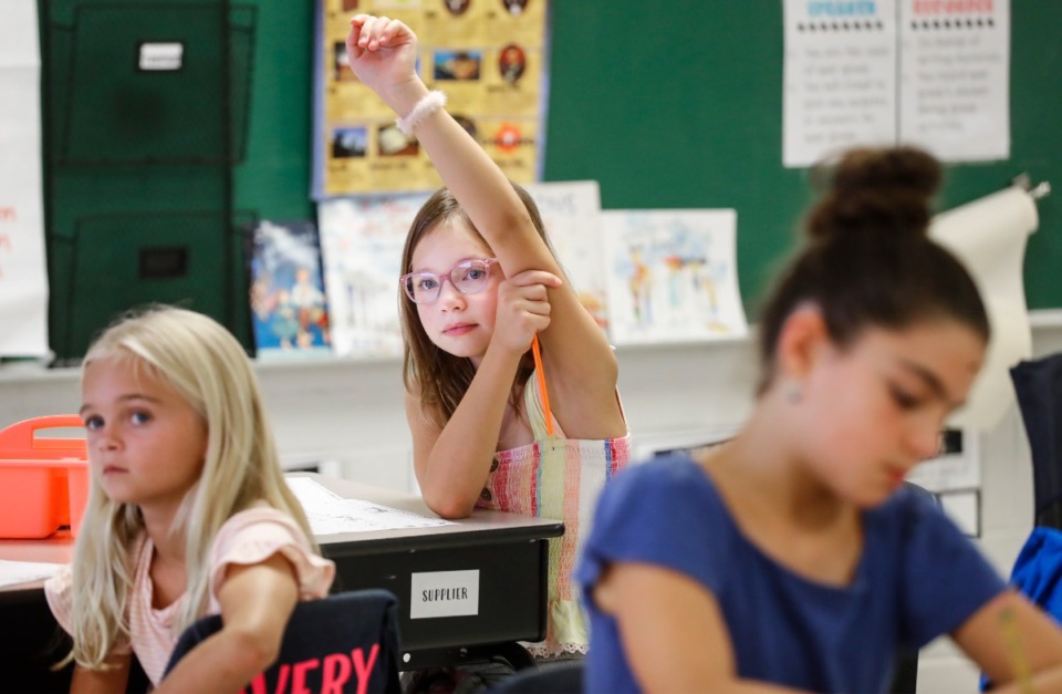 <strong>Collierville Elementary School fourth grader Lily Jones (middle) raises her hand during the first day of classes, Monday, Aug. 8, 2022.</strong>(Mark Weber/The Daily Memphian)