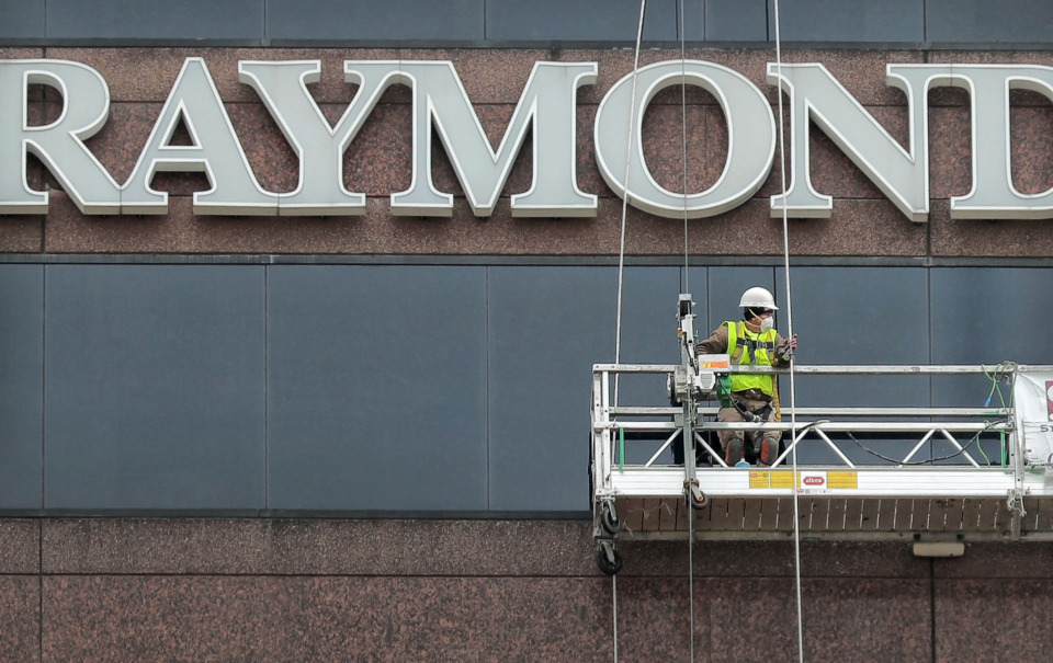 Workers with Structural Waterproofing and Restoration out of Little Rock repair windows on the Raymond James building in March. The building's landlord has announced a $3 million upgrade to the elevators that have been an issue for the building's anchor tenant.