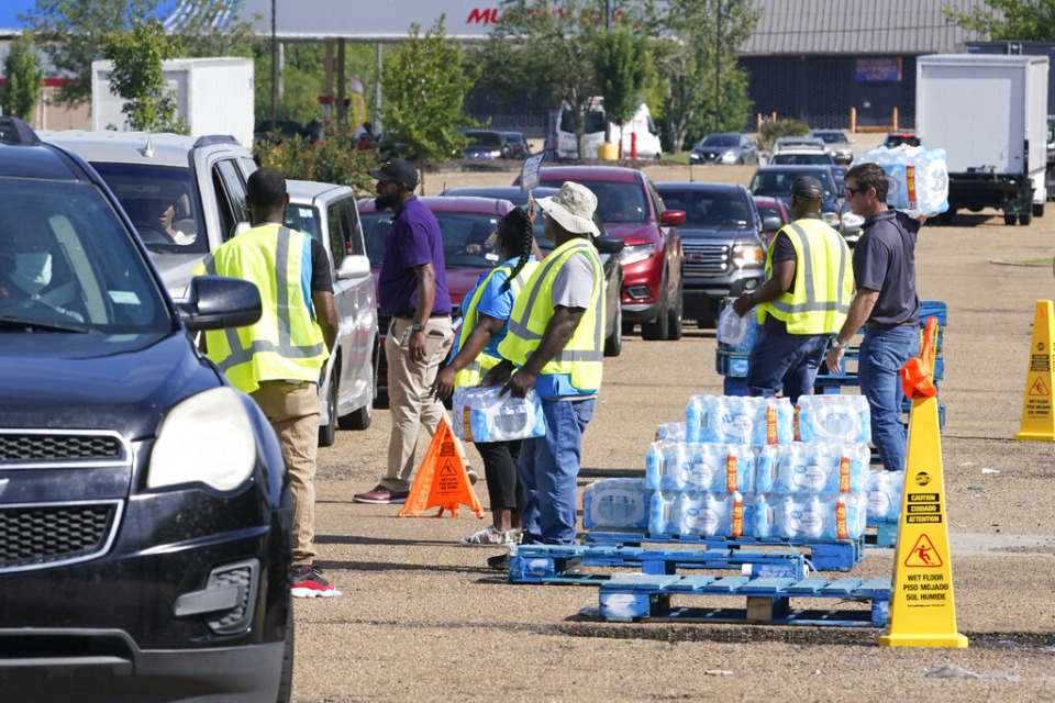 <strong>Workers at the Highway 18 Walmart distribute the last of 6,000 cases of water to long line of residents in Jackson, Mississippi, Thursday, Sept. 1, 2022. A recent flood worsened Jackson's longstanding water system problems.</strong> (AP Photo/Steve Helber)