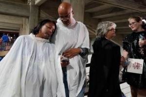 <strong>Tigers fan Herronda Harley of Memphis tries to take a standing nap, leaning against her husband Tony's shoulder while he checks on the weather report during a weather delay in the NCAA college football game between Memphis and Mississippi State in Starkville, Miss., Saturday, Sept. 3, 2022.</strong> (Rogelio V. Solis/AP)