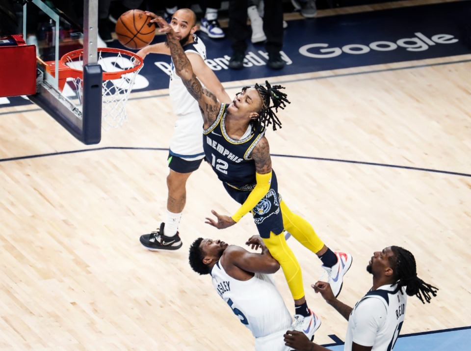 <strong>Memphis Grizzlies guard Ja Morant (top) dunks over Minnesota Timberwolves defenders Malik Beasley (left) and Naz Reid (right) during action on Tuesday, April 26, 2022</strong>. (Mark Weber/The Daily Memphian)