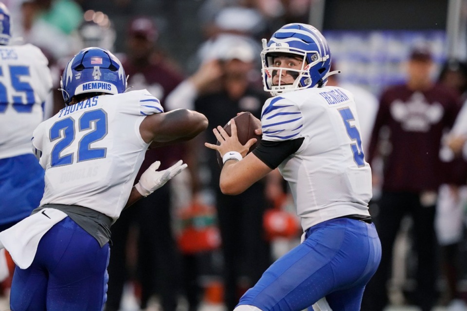 <strong>Memphis quarterback Seth Henigan (5) sets up to pass next to running back Brandon Thomas (22) during the Tigers&rsquo; game against Mississippi State in Starkville on Saturday, Sept. 3. The game was suspended in the first quarter for inclement weather.</strong> (Rogelio V. Solis/Associated Press)