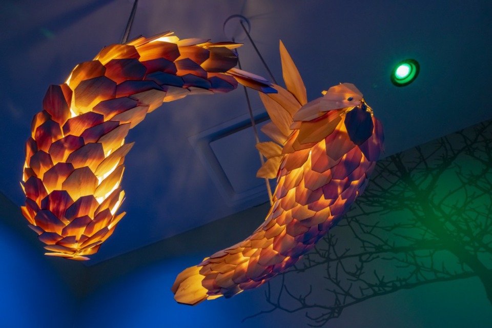 <strong>A wooden light fixture in the shape of two swimming koi illuminates a private dining room decorated in a swamp theme.</strong> (Ziggy Mack/Special to The Daily Memphian)