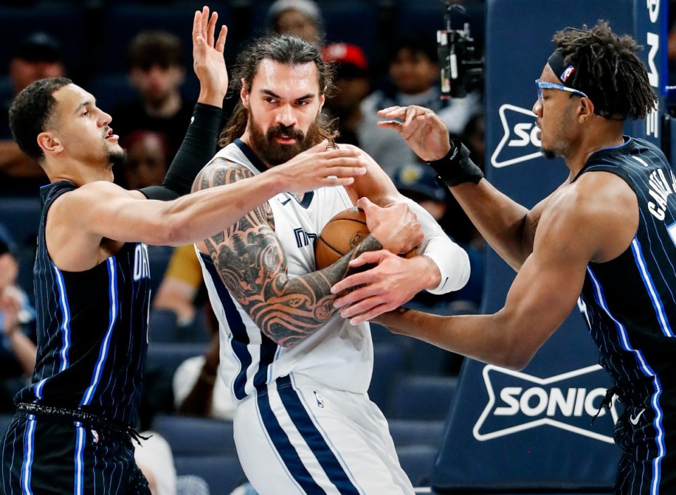 <strong>Memphis Grizzlies center Steven Adams (middle) battles Orlando Magic defenders Jalen Suggs (left) and Wendell Carter Jr. (right) for a loose ball on Monday, Oct. 3, 2022.</strong> (Mark Weber/The Daily Memphian)