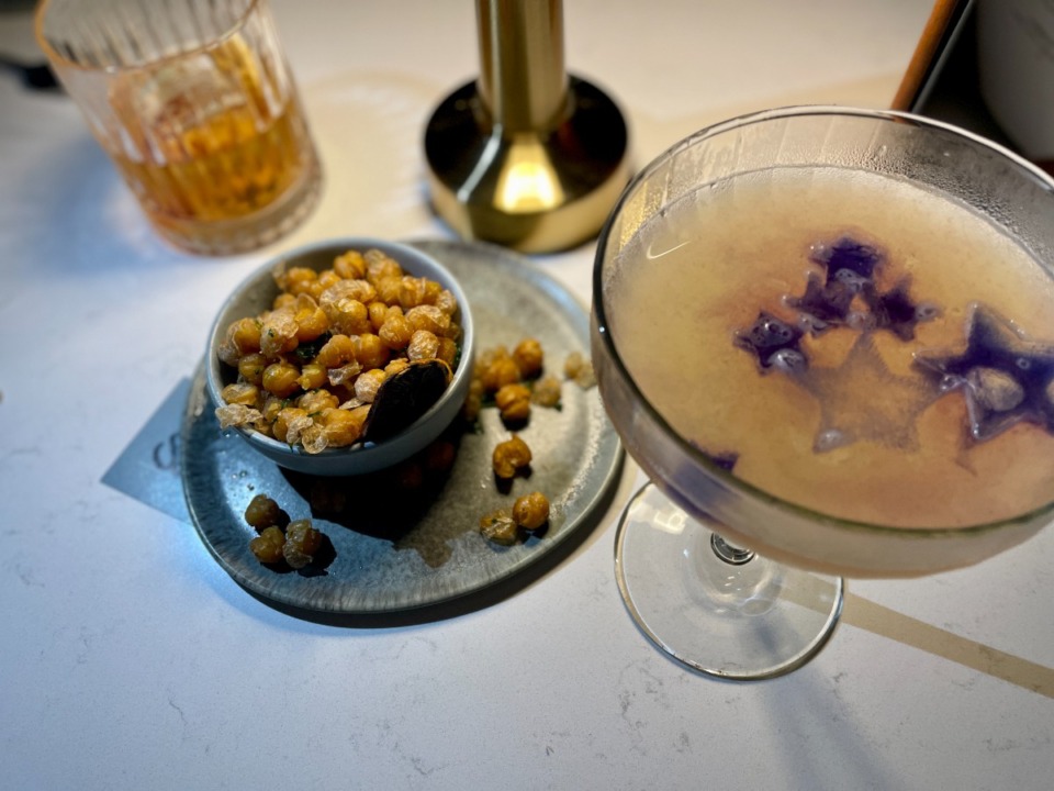 <strong>A Revelry Old Fashioned (left), fried chickpeas (middle) and Pluto&rsquo;s Favorite preceded our entrees. The Pluto&rsquo;s Favorite came with ice cubes made of butterfly pea tea.</strong> (Jennifer Biggs/The Daily Memphian)