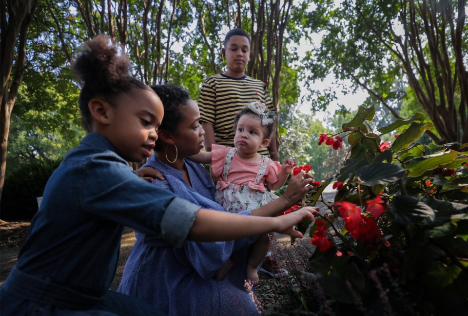 <strong>Darnesha Taylor shows her 11-month-old daughter, Charli, flowers at Overton Park. Taylor, a mother of five, survived a breast cancer scare after her Choices midwife discovered a malignant tumor during a routine pregnancy checkup.</strong> (Patrick Lantrip/The Daily Memphian)