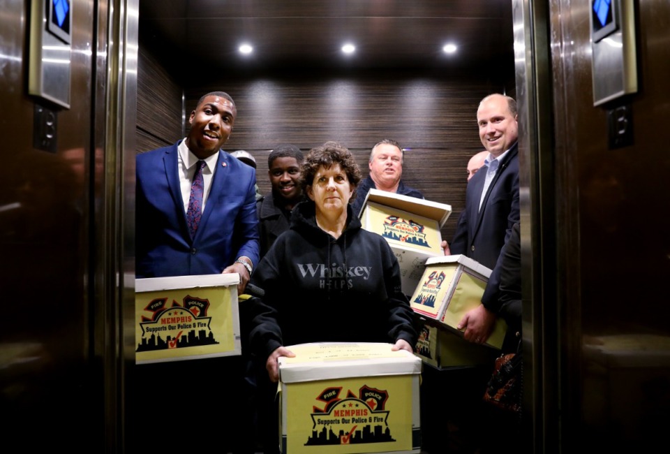 <strong>Holly Carter (center), a retired fire investigator, joins her colleagues as they take an elevator to the basement of city hall on Jan. 14, 2019, to drop off a petition that would increase sales tax by a half percent to restore insurance for local firemen and police officers.</strong> (Houston Cofield/The Daily Memphian)