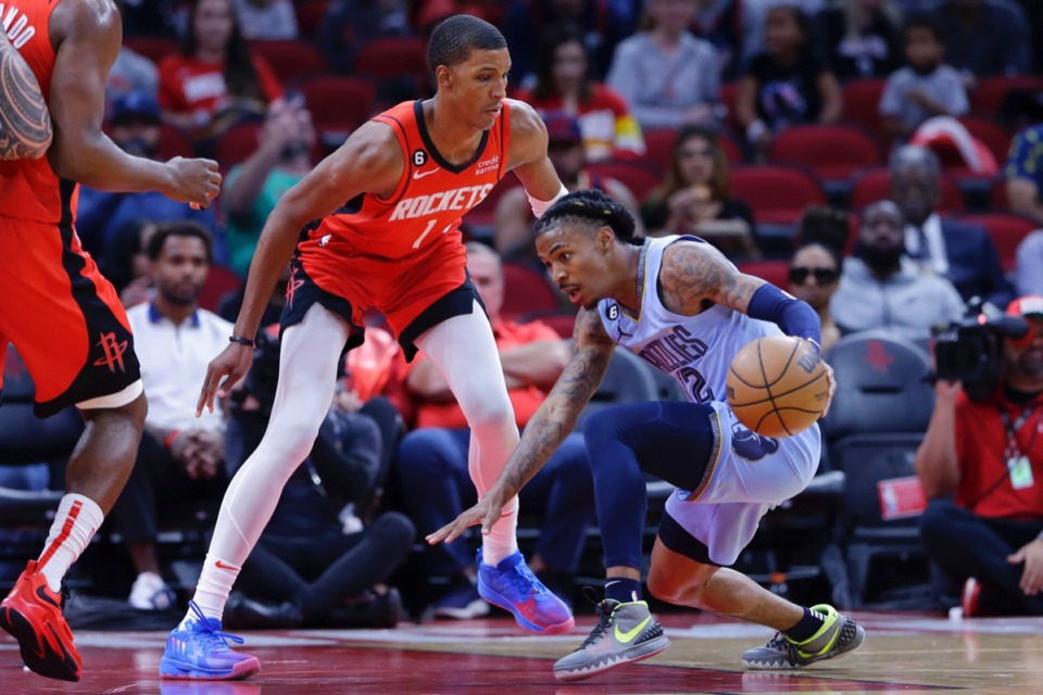 <strong>Memphis Grizzlies guard Ja Morant, right, loses his footing in front of Houston Rockets forward Jabari Smith Jr. (1) during the first half of an NBA basketball game Friday, Oct. 21, 2022, in Houston.</strong> (AP Photo/Michael Wyke)