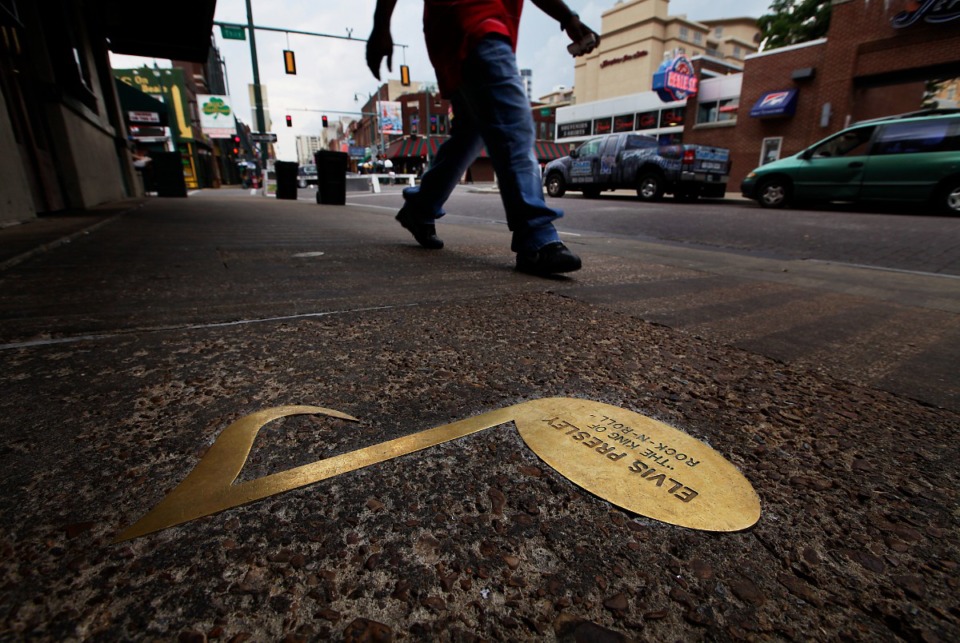 <strong>A pedestrian passes a brass note dedicated to Elvis Presley along Beale Street in 2010. Beale Street&rsquo;s Brass Note ceremonies will return after two years this month.</strong>&nbsp;(Daily Memphian file)