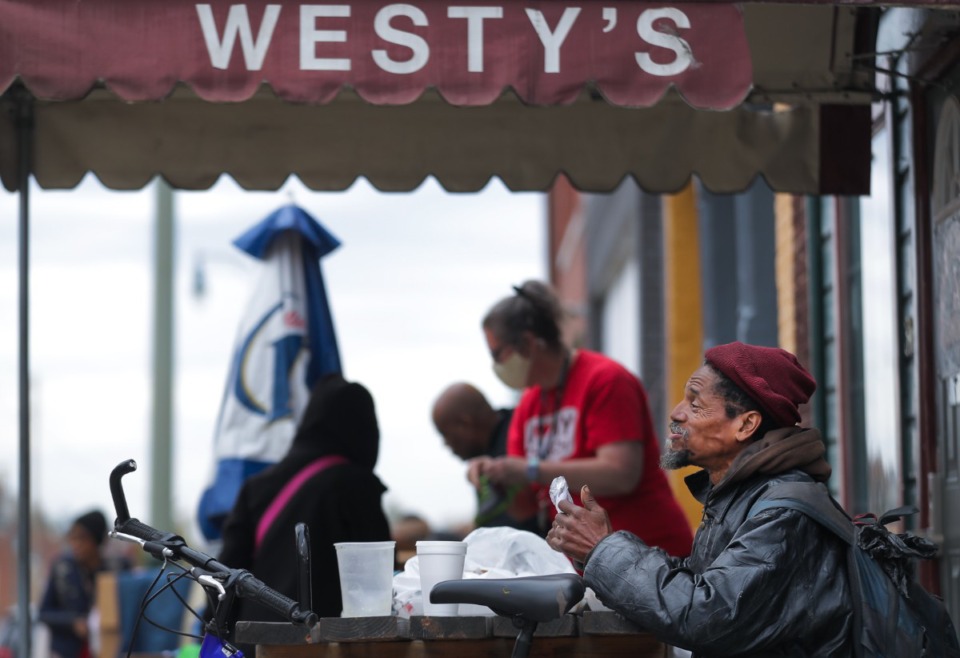 <strong>Errol Davis shares a laugh with a friend while eating his Thanksgiving meal outside of Westy's Nov. 24, 2022.</strong> (Patrick Lantrip/The Daily Memphian)
