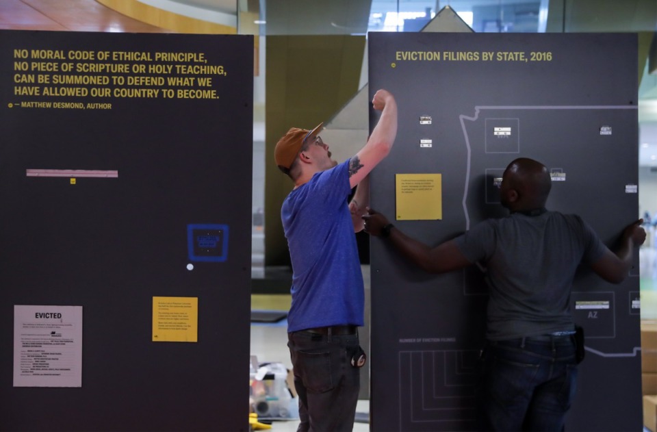 <strong>Evan Lebaroff (left) and Darnell McCurdy install the &ldquo;Evicted&rdquo; gallery at the Benjamin L. Hooks Central Library.&nbsp;The exhibit was inspired by &ldquo;Evicted: Poverty and Profit in the American City,&rdquo; a book by Matthew Desmond.</strong> (Patrick Lantrip/The Daily Memphian)