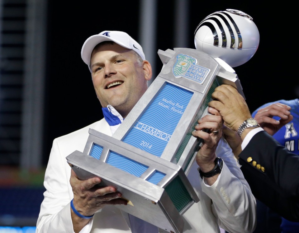 <strong>Then Memphis head coach Justin Fuente holds up the trophy after Memphis defeated Brigham Young 55-48 in double overtime during the inaugural Miami Beach Bowl football game, Monday, Dec. 22, 2014</strong> in Miami. (AP Photo/Wilfredo Lee)