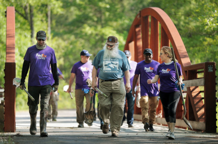 <strong>The Wolf River Conservancy's Jim Gafford (center) takes employees from FedEx out to plant trees as groups of volunteers help spruce up a new section of the Wolf River Greenway in Raleigh on April 24, 2019, in preparation for a grand opening Saturday.</strong> (Jim Weber/Daily Memphian)