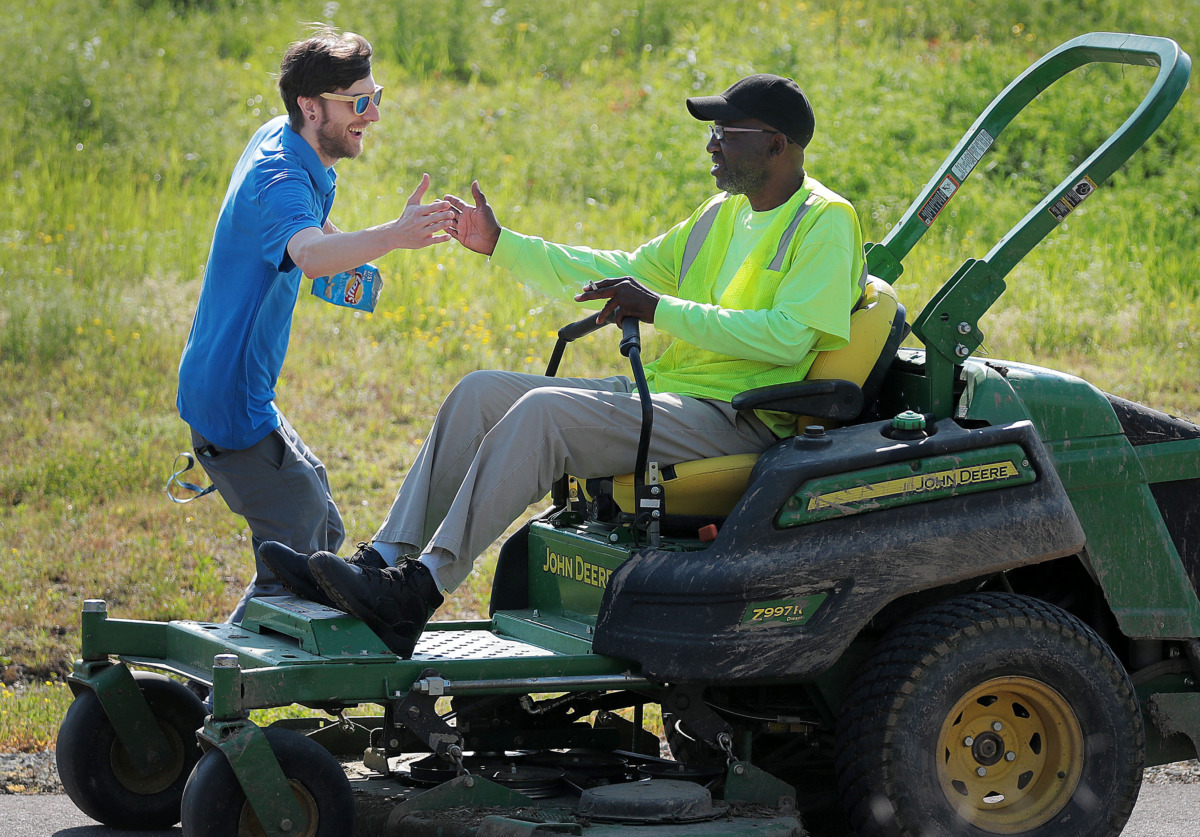 <strong>Ronnie Humphrey (right) with the Memphis parks department gets a high five from the Wolf River Conservancy's Nick Wigins as groups of volunteers help spruce up a new section of the Wolf River Greenway in Raleigh on April 24, 2019 in preparation for a grand opening Saturday.</strong> (Jim Weber/Daily Memphian)