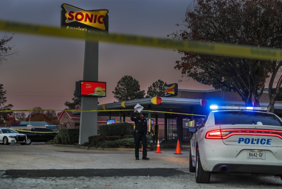 <strong>A MPD officer ducks under the tape at the crime scene of a shooting a Sonic Drive-In on Kirby Parkway.&nbsp;A 15-year-old was shot by five suspects wearing ski masks.</strong> (Patrick Lantrip/The Daily Memphian)