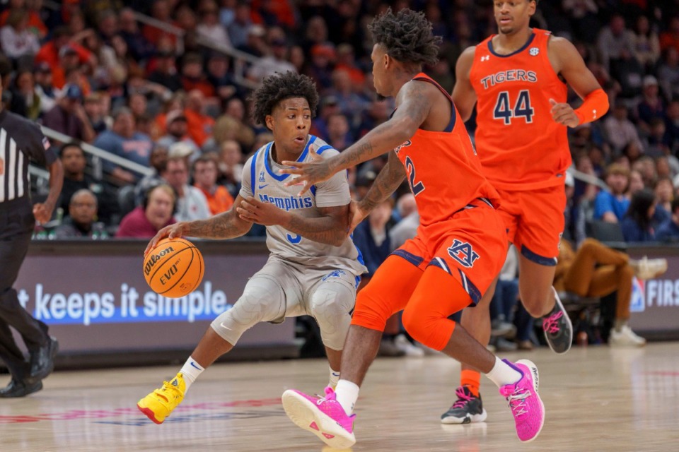 <strong>Memphis guard Kendric Davis (left), drives the ball against Auburn guard Zep Jasper during the second half of an NCAA college basketball game on Saturday, Dec. 10, 2022, in Atlanta.</strong> (Erik Rank/AP)