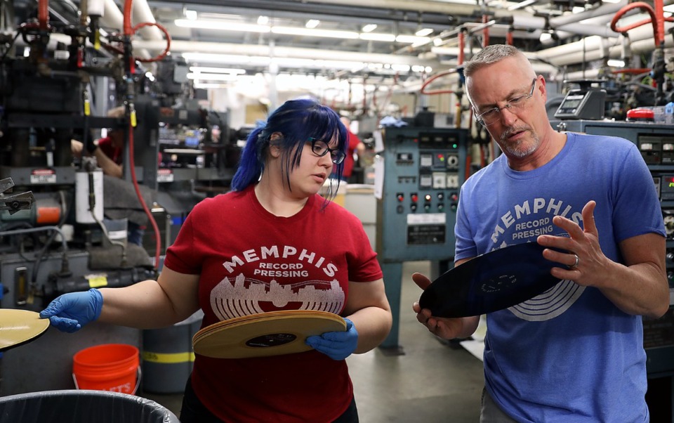 <strong>Lillia Sample and operations manager Lance Binder inspect records as they come off the presses at Memphis Record Pressing&rsquo;s Bartlett location. Their new facility is under construction and expected to open next year.</strong> (Patrick Lantrip/The Daily Memphian file)