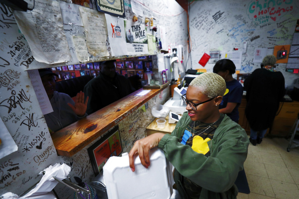 <strong>Kristen Rogers, an employee at Ching's Hot Wings, checks a customer's order before handing it over. In Memphis, where barbecue is king, the chicken wing is the reigning prince.&nbsp;</strong>(Houston Cofield/Daily Memphian)