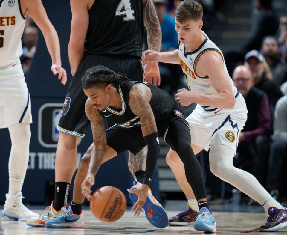 <strong>Memphis Grizzlies guard Ja Morant, left, collects a loose ball as Denver Nuggets guard Christian Braun defends in the on Dec. 20, 2022, in Denver.</strong> (David Zalubowski/AP)