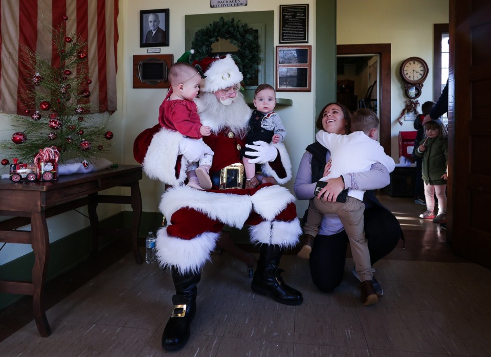 <strong>Official Germantown Santa Justin Duncan tries take a picture with twins Wyatt and Annie Kate Dugard, while their brother, George, tries to get in the lap of mom, Kelly, at the Germantown Depot Museum Dec. 17, 2022.</strong> (Patrick Lantrip/The Daily Memphian)