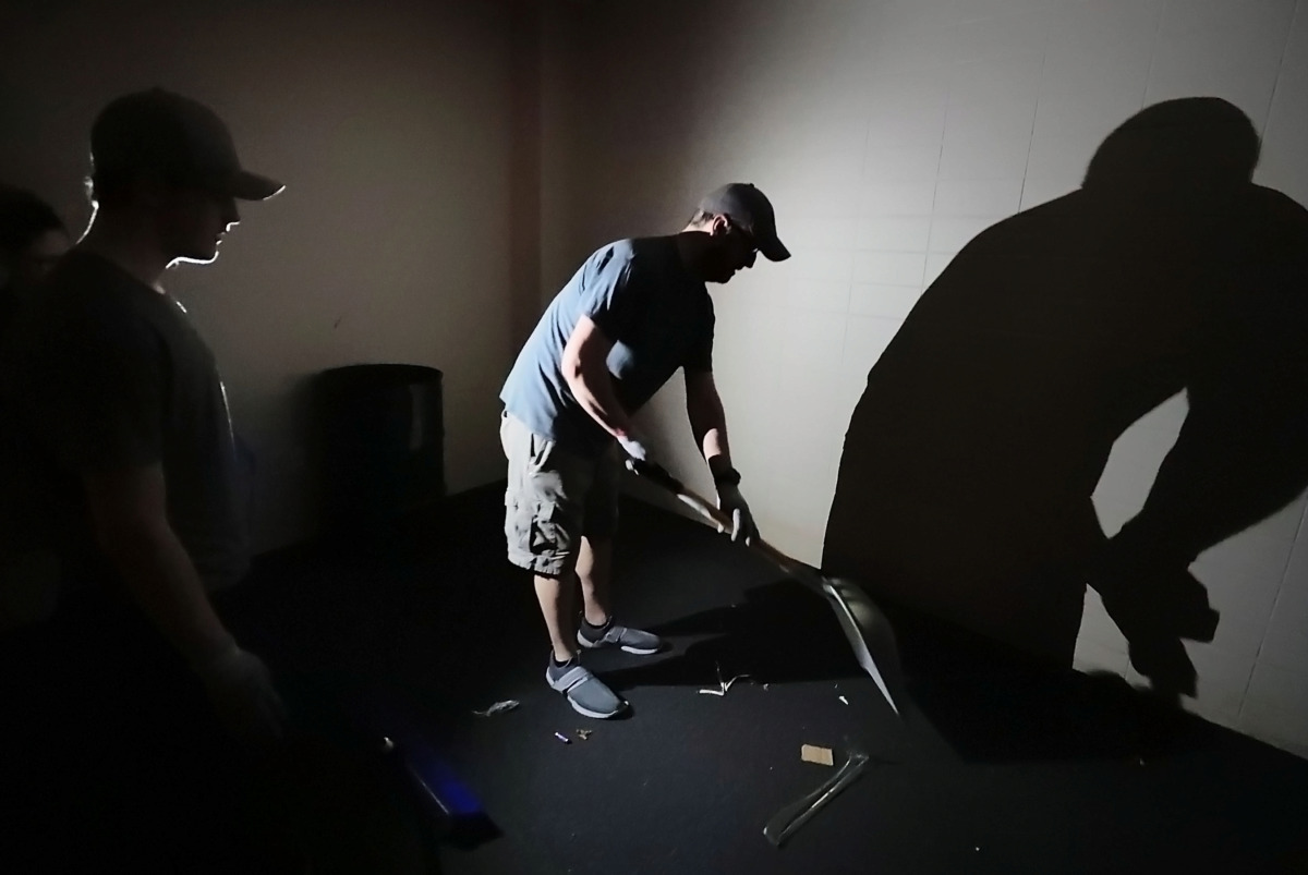 <strong>Brian George and his family clean up glass from one of the offices at the Mid-South Coliseum. They are among the volunteers who pitched in Saturday, April 27, 2019, to remove debris from the historic arena. </strong>(Jim Weber/Daily Memphian)