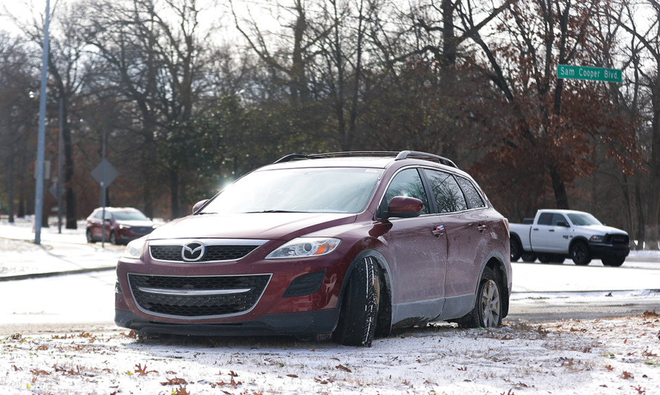 <strong>An abandoned car sits on the icy median of Sam Cooper Boulevard at East Parkway.</strong> (Patrick Lantrip/The Daily Memphian)