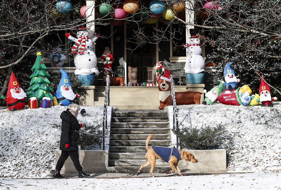 <strong>A Midtown resident braves the blistering cold temperatures and icy conditions to walker dog on Friday, December 23, 2022.</strong> (Mark Weber/The Daily Memphian)