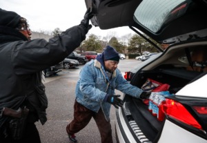 <strong>Memphis Light, Gas and Water employees Audrey Summers (left) and Ronald Shotwell handout cases of bottle water to MLGW customers on Monday, December 26, 2022. Due to numerous water main beaks MLGW customers are under a boil water advisory.</strong> (Mark Weber/The Daily Memphian)